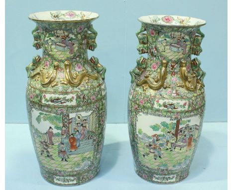 A pair of Oriental Canton style ceramic vases, decorated in typical Canton Poly-chrome enamels depicting floral designs and f