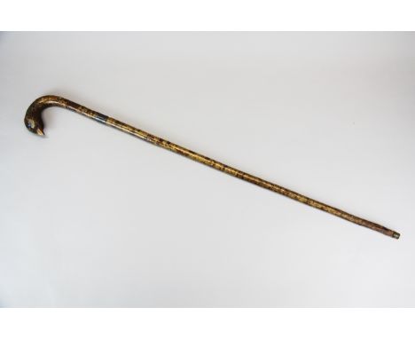 A silver mounted carved walking stick with bird head handle and blue glass eyes (crack to handle).