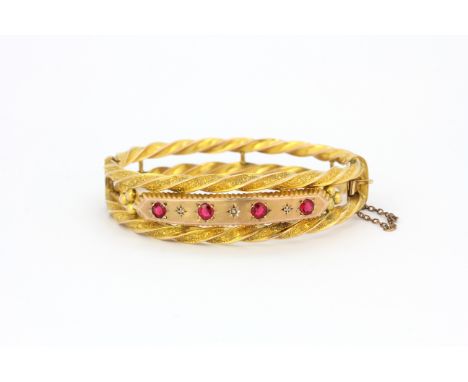 A Victorian 9ct gold bangle set with red stones and small diamonds, approx. 13.6gr.&nbsp;
