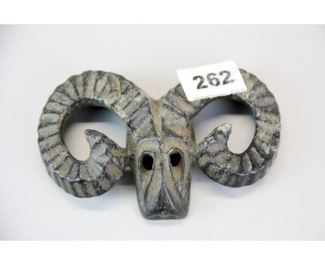 A Chinese carved jade/hardstone archaic form goat head ritual mask, W. 14cm.