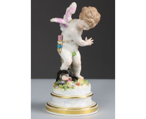 A Meissen porcelain standing figure of Cupid, his right leg caught in a gin-trap, on round simulated marble socle with gilt r