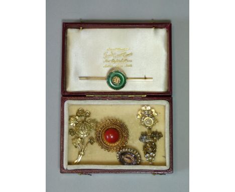 A yellow metal circular canetile brooch set cornelian cabochon, 1” dia.; a yellow metal bar brooch set green jade centred by 
