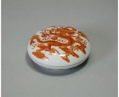 A Chinese porcelain small circular box decorated with a dragon in iron-red enamel, apocryphal Qianlong seal mark to base; 2½”