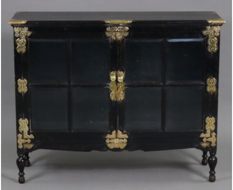 A late 19th century Aesthetic movement ebonised cabinet in the oriental style, with engraved brass mounts, fitted adjustable 