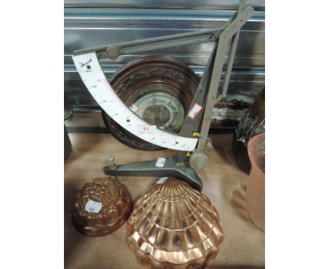 An unusual balance scale by Harris and black forest style barometer, and two copper moulds