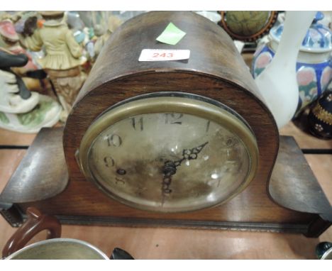 An oak bodied mantle clock with Napoleonic hat design