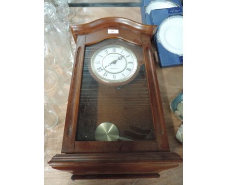 A wall mounted clock with pine frame by London Clock Co Westminister
