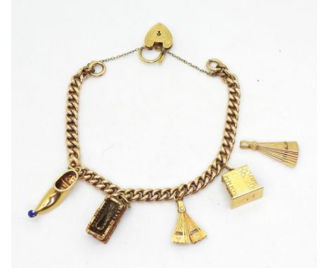 A 15ct gold curb chain charm bracelet with a decorative heart shaped clasp (retailed by Georg Jensen shop) with four attached
