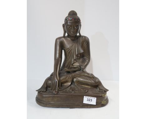 A 20th century Burmese cast bronze Shakyamuni buddha, seated in lotus pose, wearing folded and pleated robes, the head inset 