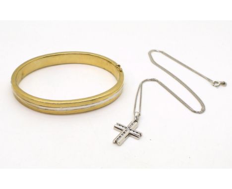 A 9ct gold bi colour gold bangle, inner diameter 6.2cm x 5.1cm, and a 9ct gold cz set cross with a 9ct white gold 46cm chain,