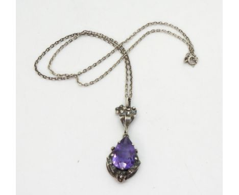 A pear shaped amethyst pendant in the style of Bernard Instone, with applied leaves and flowers, stamped silver, size of amet