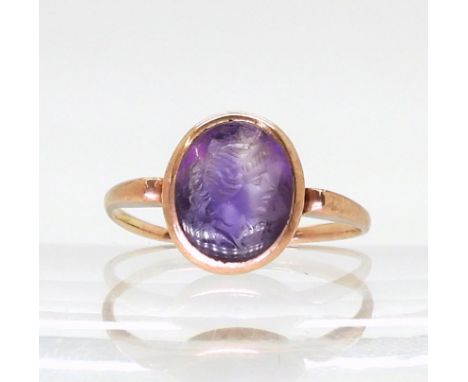 A rose coloured metal signet ring set with an intaglio carved amethyst, depicting a maiden, finger size O1/2, weight 2.5gms C