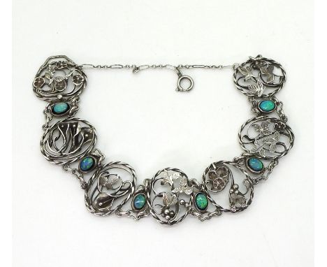 A white metal bracelet in the style of Bernard Instone each panel with a different flower theme interspaced with opal doublet