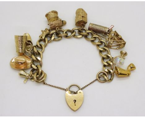 A 9ct gold charm bracelet with heart shaped clasp, to the heavy curb link chain, with eleven charms, two 14k, one 10k, one ye