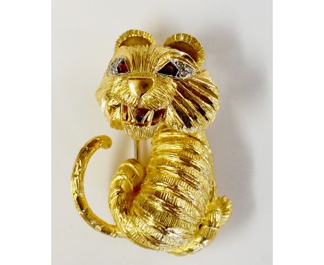 Garrard - a stylish gem set 14ct yellow gold tiger brooch, the cat with ruby and diamond eyes, textured mask, body and tail, 