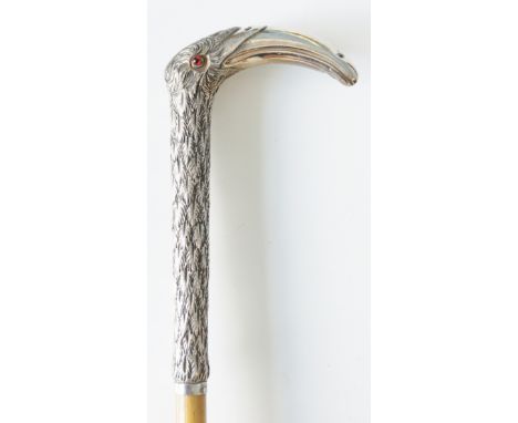 A walking stick with silver coloured metal handle cast as an exotic bird's head, glass eyes, bamboo shaft, brass ferrule, 83c