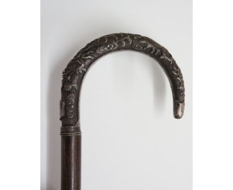 A 19th Century Chinese walking stick, the silver coloured metal handle engraved with a dragon and stylised clouds, vacant shi