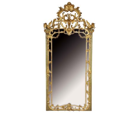 A 19th Century giltwood portrait mirror, the pierced shaped arched top finely carved with mythical beast, rococo scrolls, fol