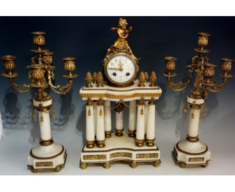 A French three piece white marble clock garniture, the clock with cylindrical drum shaped case surmounted by a winged infant 