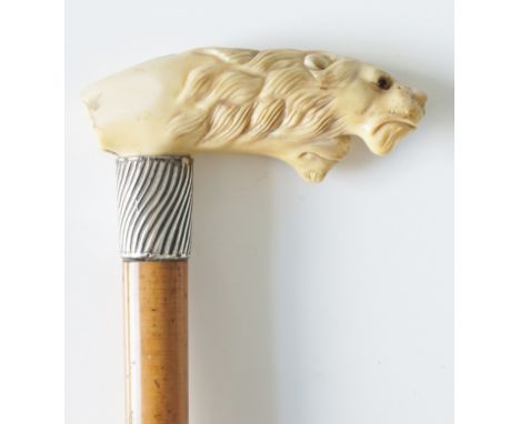 A 19th Century walking stick, the handle carved as two lion's heads, spirally ribbed silver collar, vacant shield cartouche, 