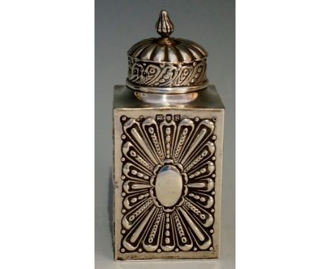A silver tea caddy, each side of the rectangular body chased and embossed with large lobed flowers, the lid lobed above band 