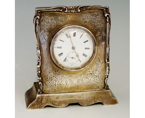 An Edwardian silver cased clock with white enamel dial, Roman numerals, subsidiary seconds dial, the front of the body engrav