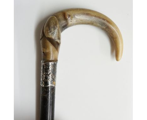 A Victorian ladies walking stick, carved horn crook handle, scroll and foliate embossed white metal collar, ebonised shaft, b