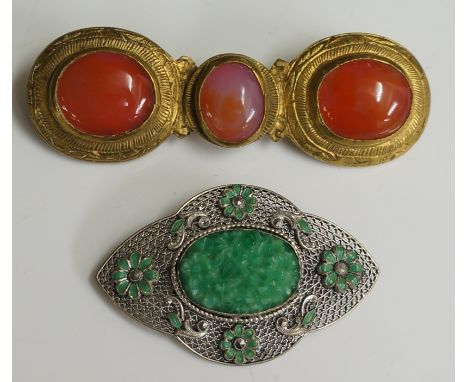 A Chinese? brass buckle style brooch centred on an oval carnelian cabochon, flanked by pair of conforming larger stones, 8.7c