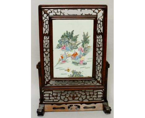 A Chinese famille rose screen, the porcelain panel painted with scholars within rock and bamboo groves, 39cm x 26cm, possibly