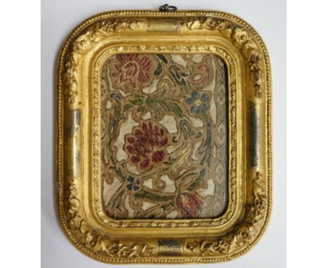 A 17th Century crewel work panel of coloured flowerheads and trailing foliage within a formal border, 16cm x 12.5cm, framed