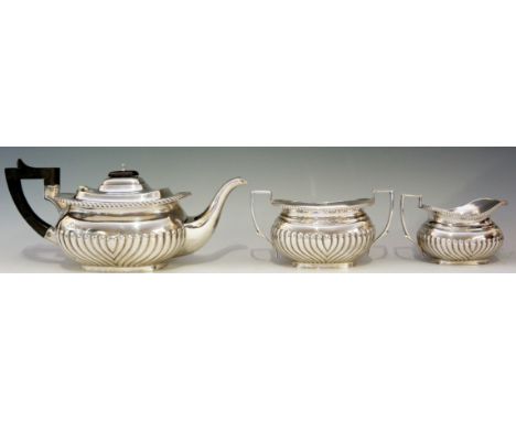 A silver tea set consisting of boat shaped teapot with ebonised handle and finial, cream jug and sucrier, all half lobed, wit