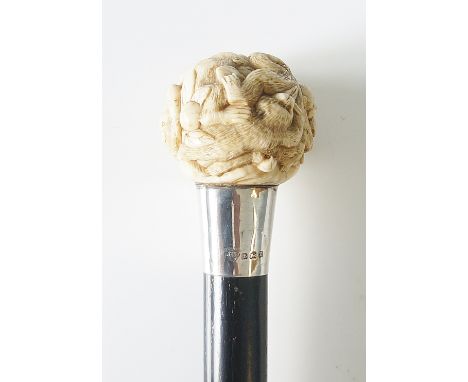 A walking stick, the spherical ivory terminal carved overall with monkeys, leaves and fruit, plain silver collar, by J Howell