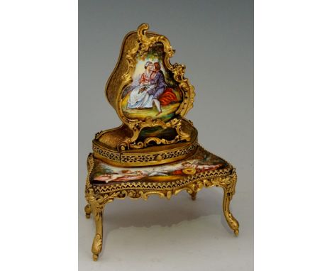 A French gilt metal and enamel miniature musical bonheur du jour, the top with enamel panel of courting couple above a shaped