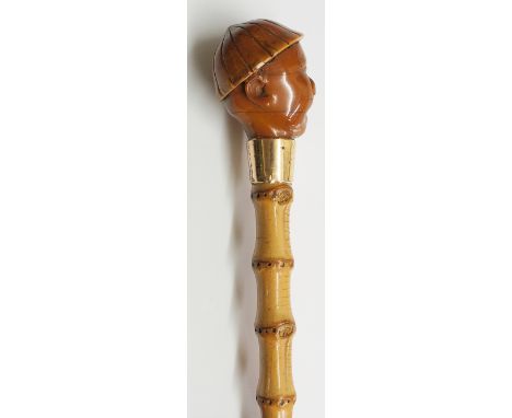 A 19th Century Chinese walking stick, the terminal carved as a shouting man's head, gold coloured metal ferrule stamped J.H.,