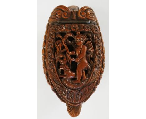 A fine 18th Century coquilla nut snuff box of stylised dog form, the hinged lid finely pierced and carved with a winged cheru