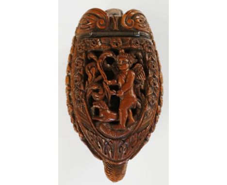 A fine 18th Century coquilla nut snuff box of stylised dog form, the hinged lid finely pierced and carved with a winged cheru