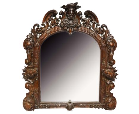 A 19th Century oak hunting lodge mirror, finely carved overall, the top with head and shoulder portrait of a bearded man wear