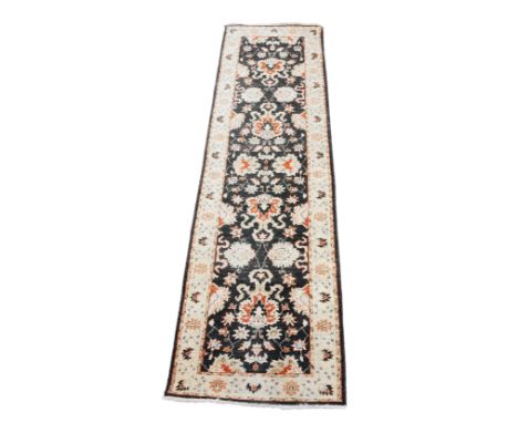 A Caucasian runner, the central rectangular panel with repeating foliate design in red, yellow and cream on a black ground, c