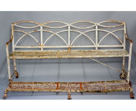 A regency wrought iron reeded four panel back strap iron bench with foot rest, wheels to one end, 204cm wide, 105cm high, Cir