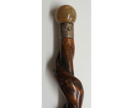 A 19th Century walking stick with carved horn ball pommel, silver collar inscribed JG, rustic style twisting shaft, brass fer