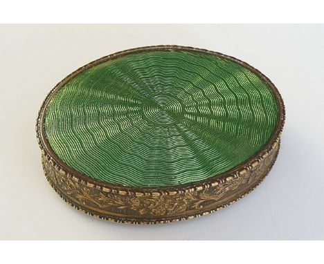 A brass and green engine turned enamel oval patch box, foliate cast border, 6cm wide, early 20th Century