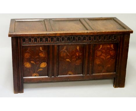 A late 17th Century oak three panel blanket chest, the top with channelled frame above a frieze gouge carved, the three panel