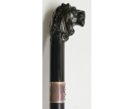 A good 19th Century walking stick - the ebony terminal carved as a lion's head, the back of which has a shield shaped cartouc