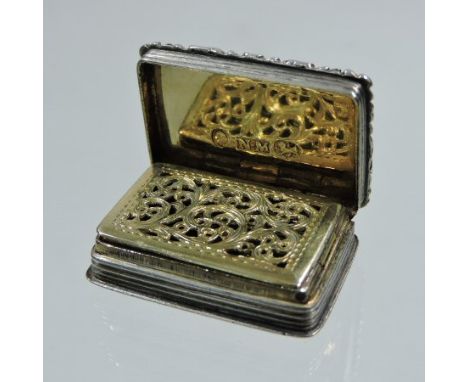 A George IV silver vinaigrette, of hinged rectangular shape, with engine turned decoration and an ornate pierced gilt grille,