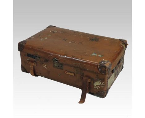 An early 20th century brown leather travelling case, inscribed H.C.D. and bearing various labels, 85cm. This trunk has come d