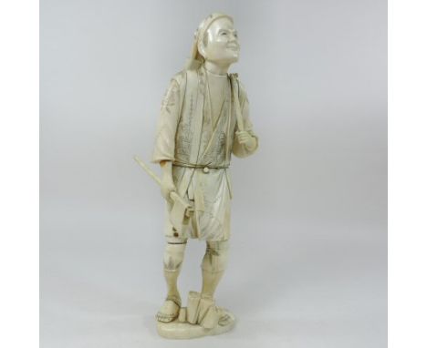 A late 19th century Japanese carved ivory figure of a woodman, shown standing carrying a bag of logs with an axe in his hand,