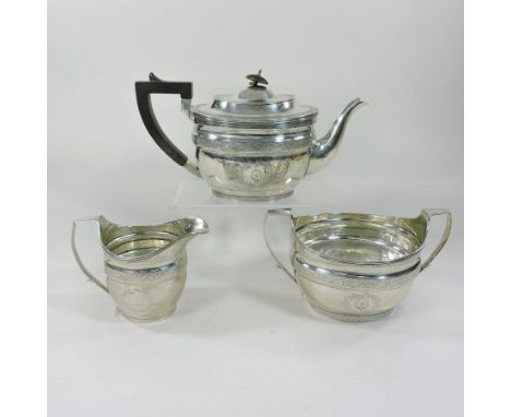 A George III and later matched silver tea service, comprising a teapot and cover, of oval shape, Dublin 1915, 30cm long, a Ge