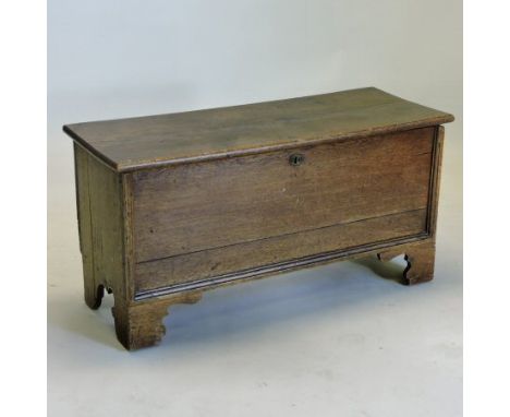 An 18th century oak six plank coffer, with a hinged lid on bracket feet, 88cm