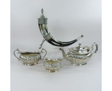 A silver plated three piece tea service, comprising a teapot and cover, sugar and cream jug, together with a pewter mounted h