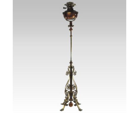 An Arts and Crafts copper and brass standing oil lamp, in the manner of W. A. S. Benson, with a copper reservoir, on a scroll
